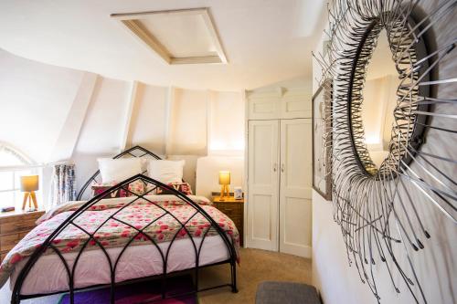 a bedroom with a bed and a mirror at Round House East in Veryan