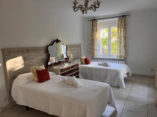 a bedroom with two beds and a mirror at Villa Merenciana in Agoncillo