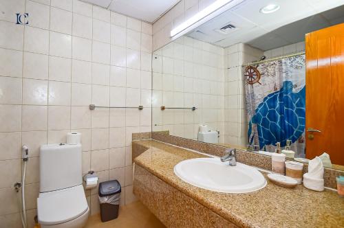 a bathroom with a sink and a toilet and a mirror at Luxury Escapes - Tranquil Retreat - Studio Apts near Metro and Mall - Discovery Gardens - SHAR & MCL in Dubai