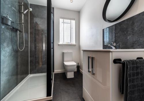 a bathroom with a shower and a toilet and a sink at Shoreland Lodges - Cherry Lodge in Fort Augustus