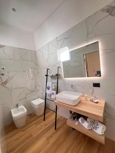 a bathroom with a sink and a toilet and a mirror at 49 Downtown Pompeii in Pompei