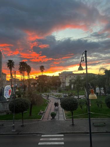 a sunset in a city with palm trees and a street at 49 Downtown Pompeii in Pompei