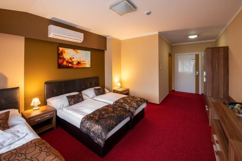 a hotel room with two beds and a tv at Hotel Glamour in Kaluža
