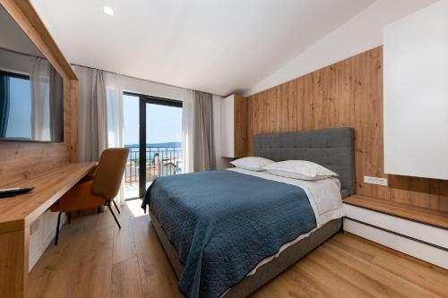 a bedroom with a bed and a desk and a window at Villa Senzen in Baška Voda