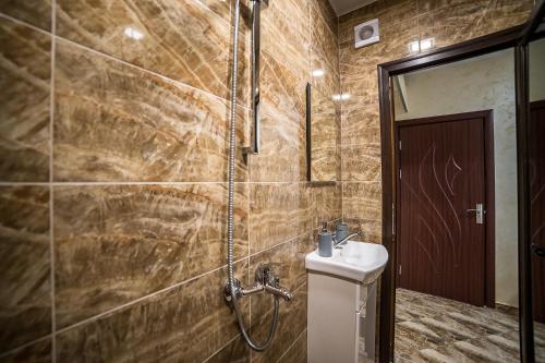 La salle de bains est pourvue d'une douche et d'un lavabo. dans l'établissement Къща за гости Алекс, à Karlovo