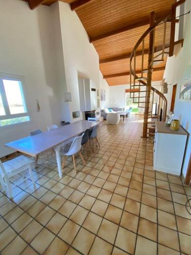 une grande chambre avec une table, des chaises et un escalier dans l'établissement Maison familiale 4 chambres avec grand jardin, particulier, à Corsept