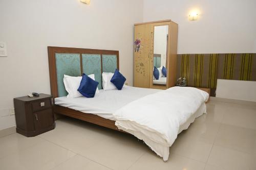 a bedroom with a large bed with blue pillows at ownstay chhatarpur in New Delhi