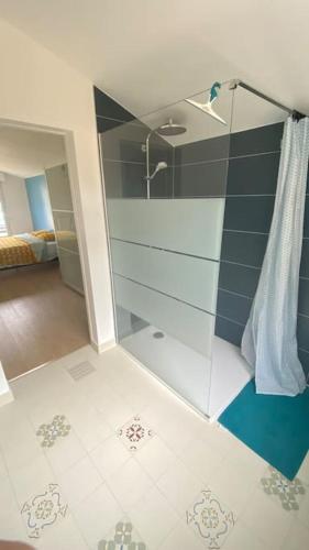 une douche avec une porte vitrée dans une salle de bain dans l'établissement Maison familiale 4 chambres avec grand jardin, particulier, à Corsept