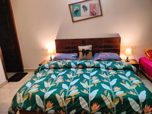 a bedroom with a large bed with a colorful bedspread at Blue Heart Home 1 BHK - Spacious Flat in Tapovan in Rishīkesh
