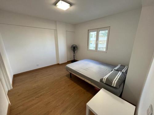 - une petite chambre avec un lit et une fenêtre dans l'établissement Precioso apartamento cerca de la playa en Villajoyosa, à La Vila Joiosa
