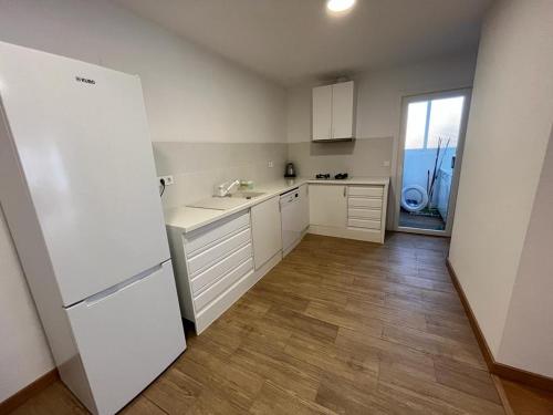 La cuisine est équipée de placards blancs et d'un réfrigérateur blanc. dans l'établissement Precioso apartamento cerca de la playa en Villajoyosa, à La Vila Joiosa