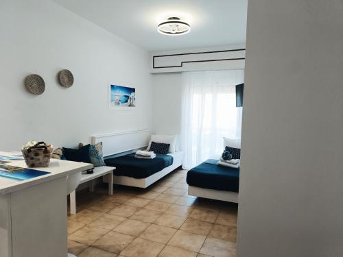 a living room with two beds and a table at Nautilus City Studios & Apartments in Rhodes Town