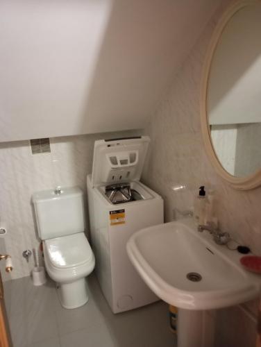 a small bathroom with a toilet and a sink at Dúplex c/Álvaro Cunqueiro 1-3-C1 in Foz