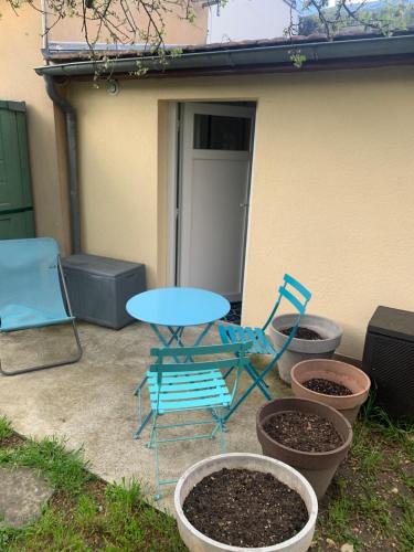 un patio con tavolo, sedie e piante di Mozart studio a Joinville-le-Pont