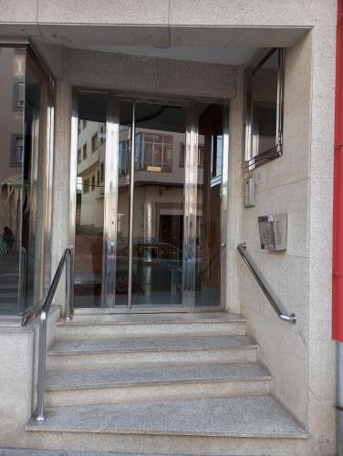 a staircase leading to a building with glass doors at Dúplex c/Álvaro Cunqueiro 1-3-C1 in Foz