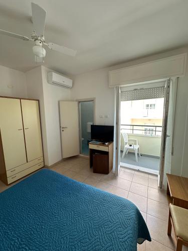 a bedroom with a bed and a desk and a window at Hotel La Plage in Cattolica