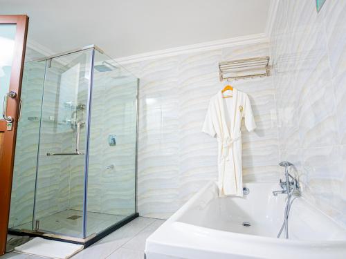a bathroom with a shower and a white robe hanging on a wall at LIGHT VILLAS in Nairobi