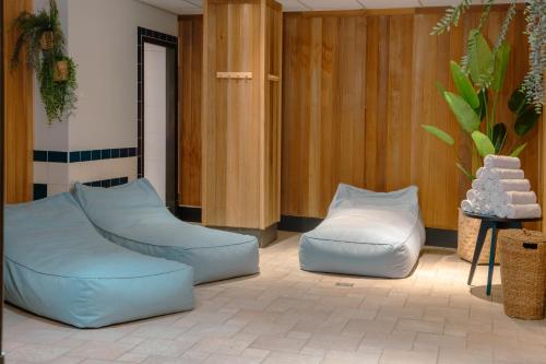 a room with two blue chairs and a table at Mercure Hotel Tilburg Centrum in Tilburg