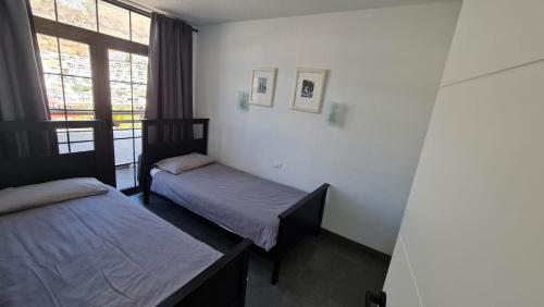 a room with two beds and a window at Fresitas Holiday Home in Puerto Rico de Gran Canaria