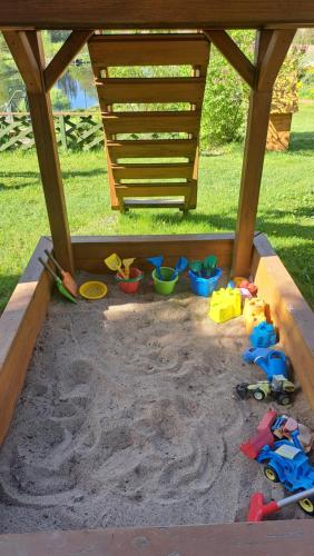 a sandbox with some toys in the sand at Dolina Miodu - Kaszuby, Sauna, Gorąca Balia in Borowina