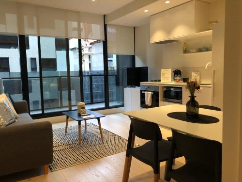 een keuken en een woonkamer met een tafel en stoelen bij Apartment Chole in Melbourne