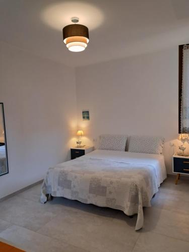 モンテロッソ・アル・マーレにあるAffittacamere Sophieの白いベッドルーム(ベッド1台、ランプ2つ付)