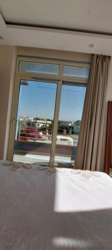 ein Schlafzimmer mit einem Bett und einem großen Fenster in der Unterkunft Mirage Bay Hotel & Aqua Park , Suites , flates in Hurghada