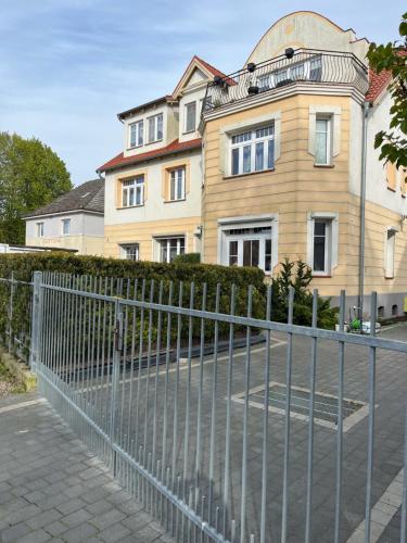 a house with a fence in front of it at Apartament z ogródkiem in Rewal