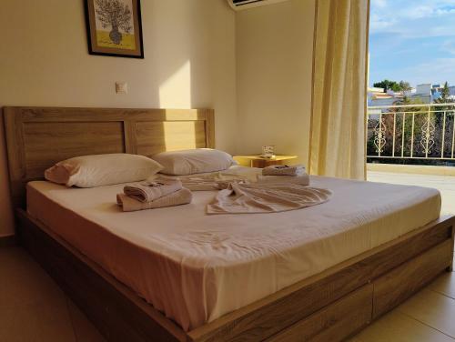 a bed with towels on it in a room with a window at Finikas Spata Holiday Apartment in Spáta