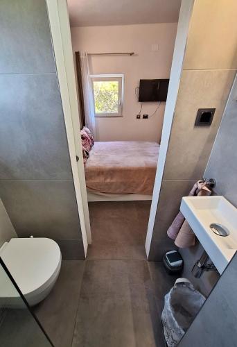a small bathroom with a toilet and a sink at By the Mill in Rogoznica