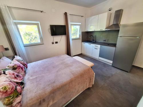 a small kitchen with a table and a refrigerator at By the Mill in Rogoznica