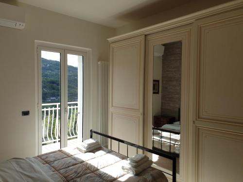 een slaapkamer met een bed en een groot raam bij Il Balcone su Ascoli Piceno in Folignano