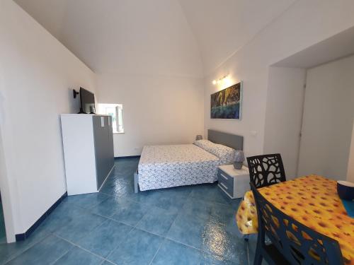 a room with two beds and a table and a refrigerator at Casa Acqua Marina Le Forna in Ponza
