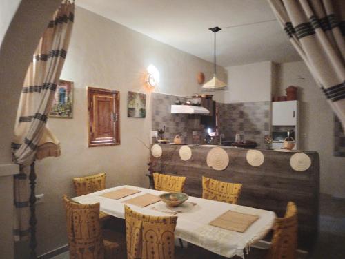 una mesa y sillas en una cocina con mesa y mesa en Djerba Rêve Vacances Emna EL Beya, en Midoun