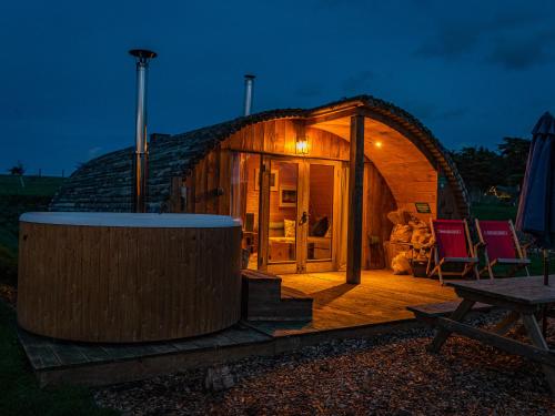 a small wooden cabin with a round roof with a wooden deck at Modulog 2 At Tapnell Farm in Yarmouth
