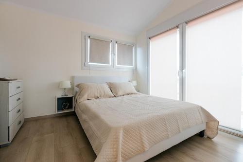 a white bedroom with a bed and a window at Mylarakia in Chios