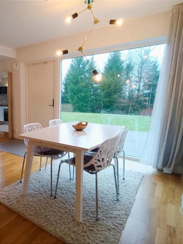 a dining room with a table and chairs and a large window at Modern, private & fully equipped for 3 & 2 children, near forest, with kitchen washer, pets friendly in Floda
