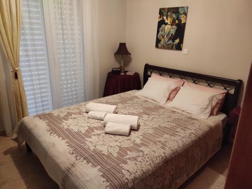 - une chambre avec un lit et des serviettes dans l'établissement MARGARET VACATION HOUSE 52, à Kamena Vourla