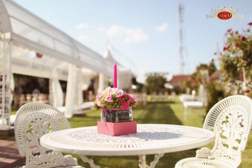a table with a candle and a vase of flowers on it at Hotel Roco in Izvin