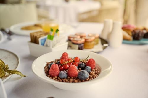 a bowl of berries on a white plate on a table at Grand Hotel Imperiale in Forte dei Marmi