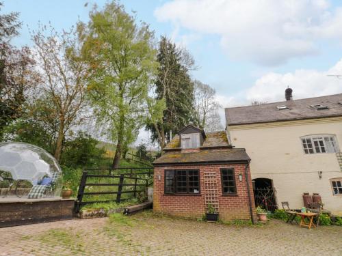 an exterior view of a house and a fence at The Wheelhouse at Dudgeley Mill in Church Stretton