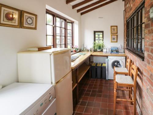 a kitchen with a white refrigerator and a sink at The Wheelhouse at Dudgeley Mill in Church Stretton