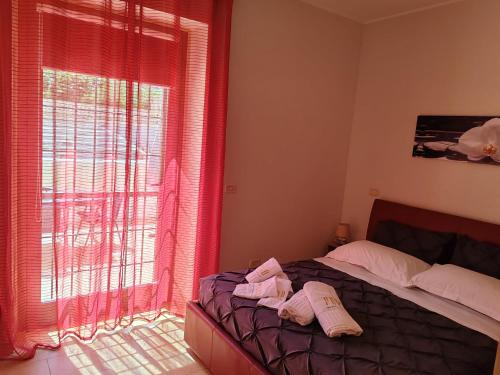 um quarto com uma cama e uma janela com cortinas vermelhas em Verso Oriente em Brindisi