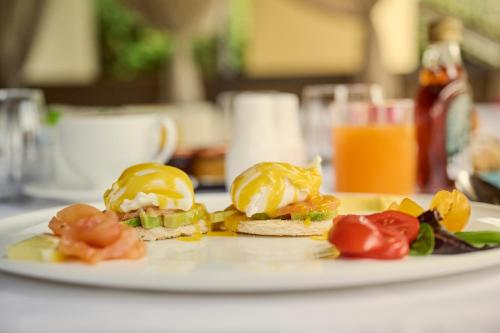 a plate of food with eggs and tomatoes on a table at Grand Hotel Imperiale in Forte dei Marmi