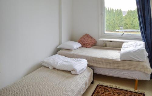 two twin beds in a room with a window at Amazing Home In Enhörna With Sauna in Enhörna