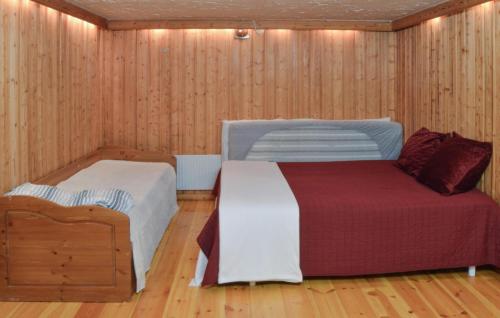 EnhörnaにあるAmazing Home In Enhrna With Saunaのウッドパネルのベッドルーム1室(ベッド2台付)