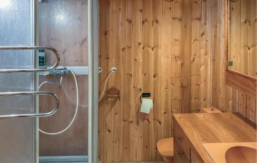 Łazienka z drewnianymi ścianami, umywalką i prysznicem w obiekcie Amazing Home In Enhrna With Sauna w mieście Enhörna