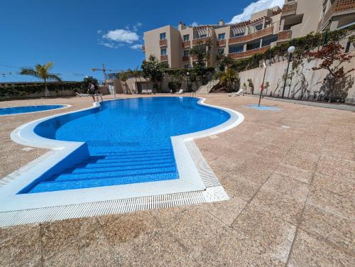 una piscina en medio de un patio de azulejos en Flat in La Tejita, Médano, en Granadilla de Abona