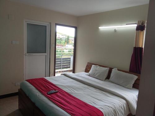 um quarto com uma cama grande e uma janela em Queenhill Homestay Ooty em Ooty
