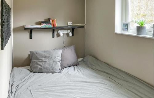 1 cama con almohada y estantería en la pared en Amazing Home In Glanshammar With Wifi en Glanshammar